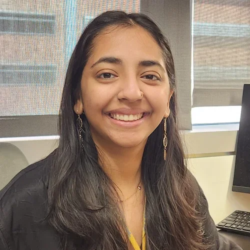 Aniketa Sinha, graduate student, sitting at desk
